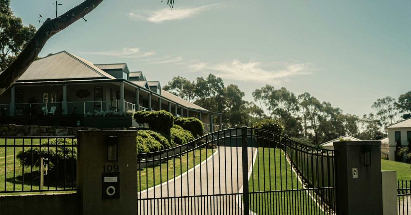 Photo by The Drink Break a gated driveway with a house in the background